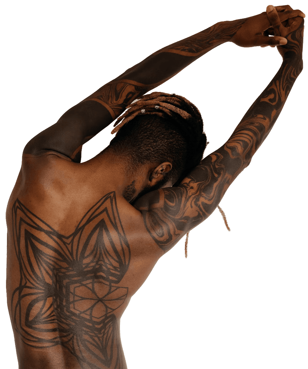 Black man facing away with his tattooed arms outstretched